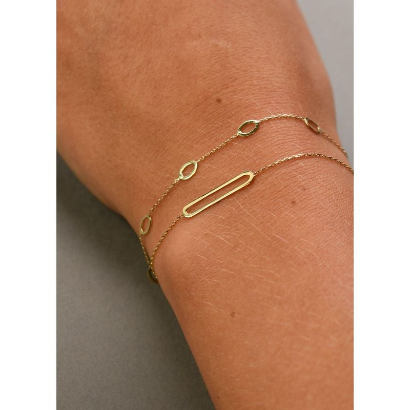 Bracelet minimaliste Bahia Oval JACKIE 585 MILLIEMES doré porté au poignet, style layering élégant a