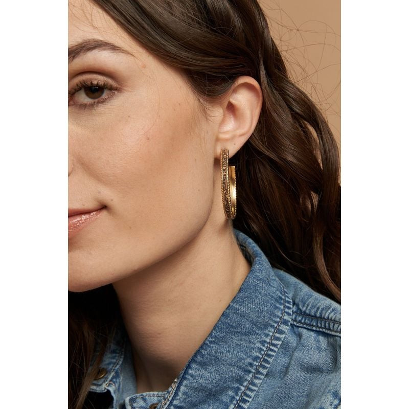 Boucles d'Oreilles Créoles FlowersForZoé Léo Cuir Acier Doré portées en lifestyle, éclat doré et cui