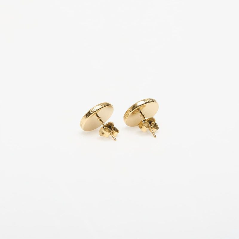 Vue arrière des boucles d’oreilles à clous GUESS G Talisman dorées avec logo gravé et fermoirs papil
