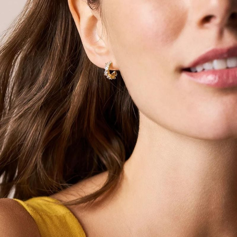 Boucles d'oreilles Créoles Fossil Mixed Shapes Ellis Laiton Doré portées par un mannequin dans un st