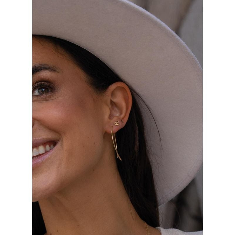 Gros plan sur une femme souriante portant les Boucles d'oreilles Clous Jackie Coeur Or Jaune, élégan