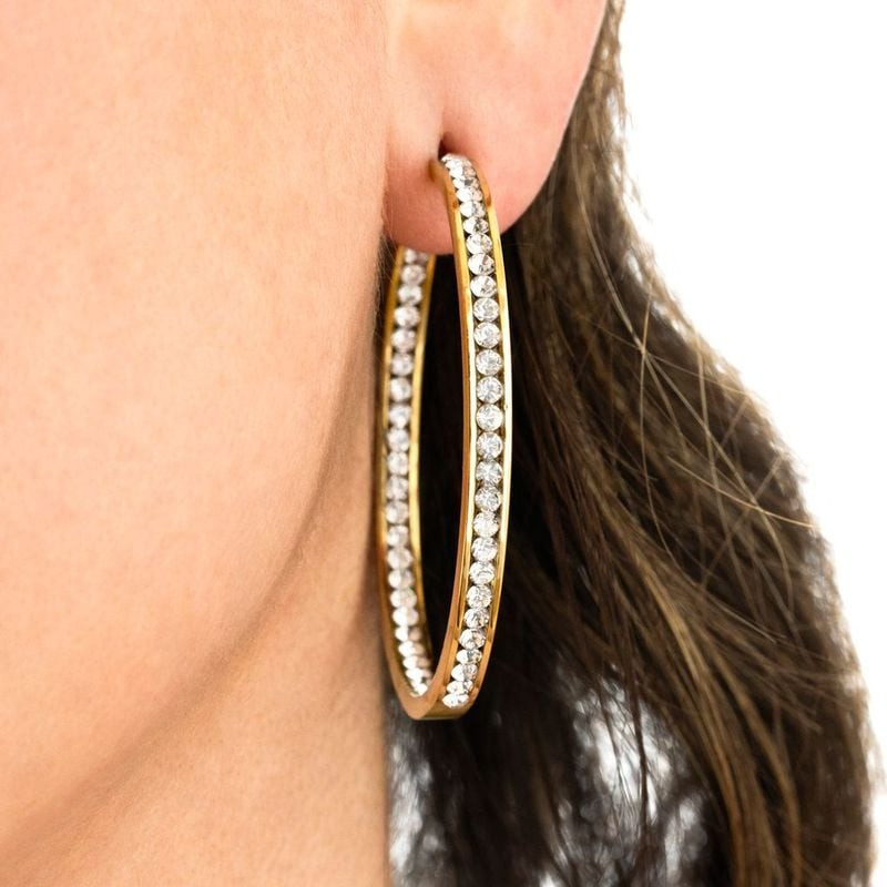 Gros plan sur l'oreille d'une femme portant la créole dorée Lotus Style ornée d'une rangée de strass