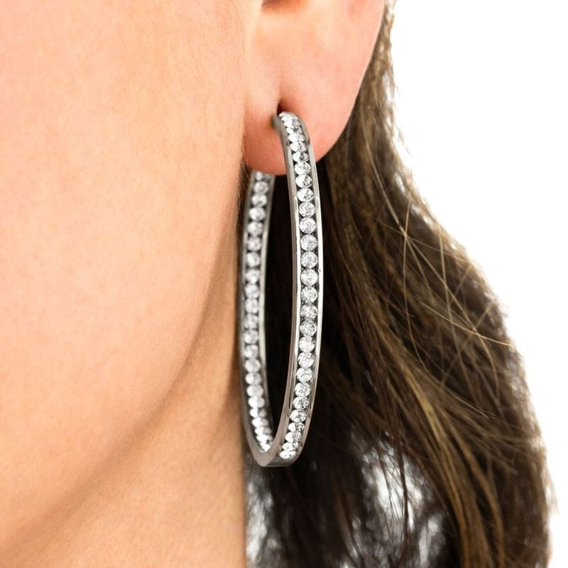 Boucles d'oreilles clous Lotus Style Urban Woman en acier poli portées par un mannequin en tenue urb