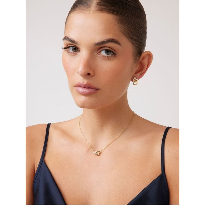 Mannequin portant des boucles d'oreilles puces Guess Beloved cœur doré et un collier cœur assorti