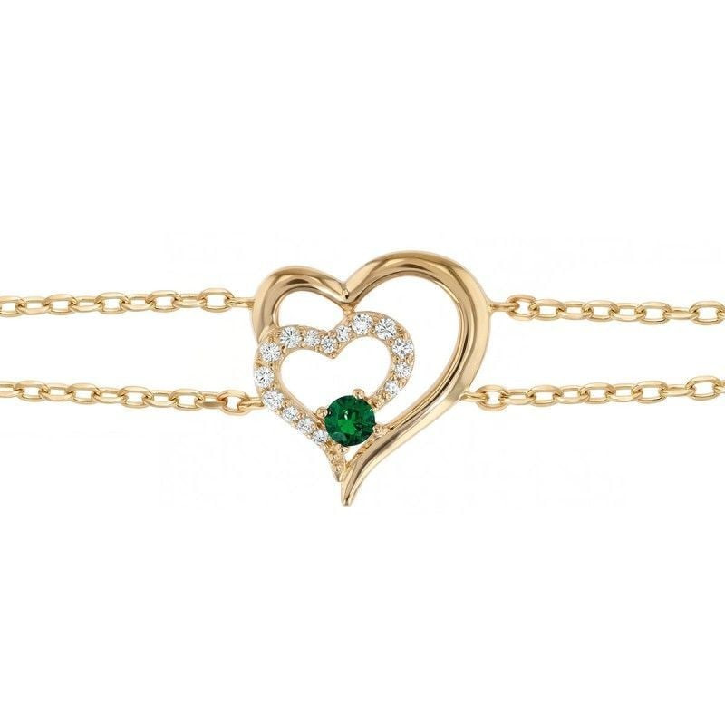 Gros plan sur le pendentif double cœur entrelacé pavé de zirconium blanc et d'une pierre vert émerau
