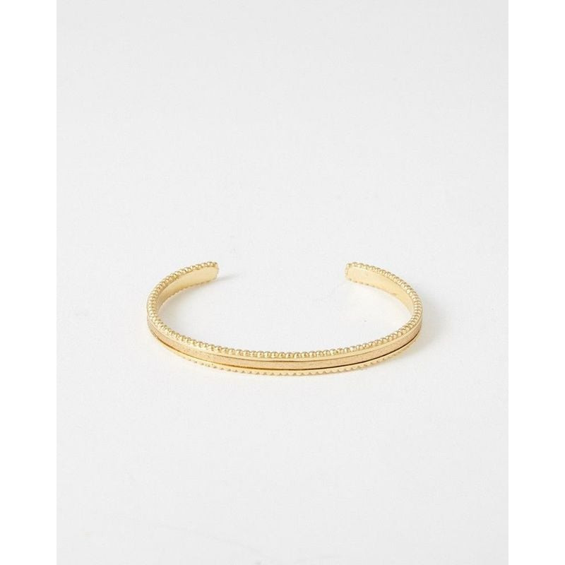 Vue de face du bracelet jonc doré ouvert, montrant son bord perlé et sa bande centrale en cuir doré 