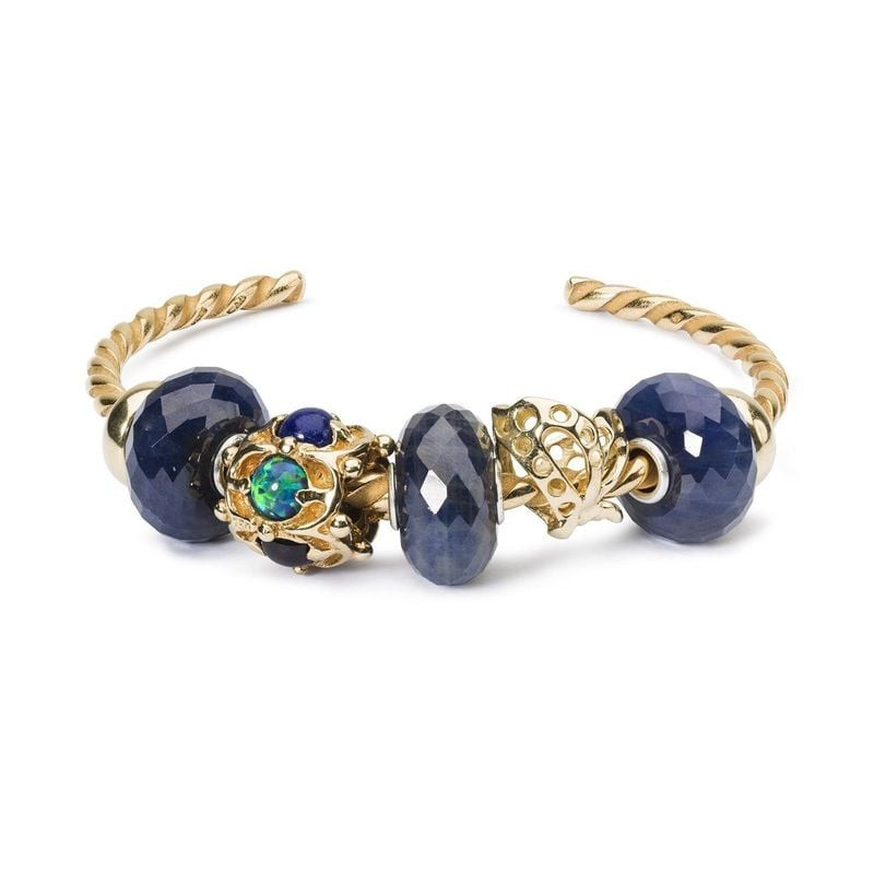 Deux perles Trollbeads Saphir sur un jonc torsadé en or avec des charms Trollbeads ornés en or et op