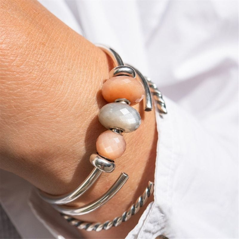 Perle de Bracelet Trollbeads Pierre de Lune Grise portée au poignet, dans une ambiance naturelle et 