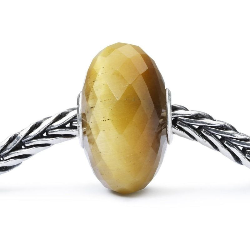 Vue macro de la perle Trollbeads quartz œil-de-chat facettée, enfilée sur une chaîne en argent tress