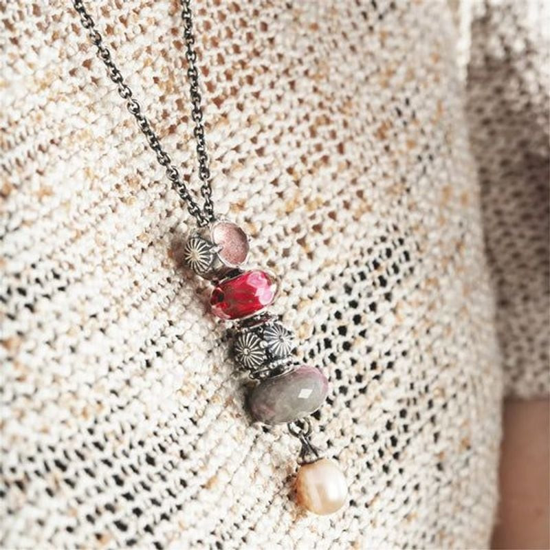 Perle Trollbeads Facettée Pierre Rubis Rouge sur fond ambiant, éclat naturel et reflets rouges