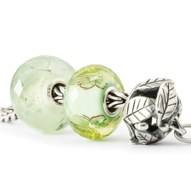 Perle Trollbeads Tourmaline prehnite présentée sur chaîne en argent avec charms feuille en argent et