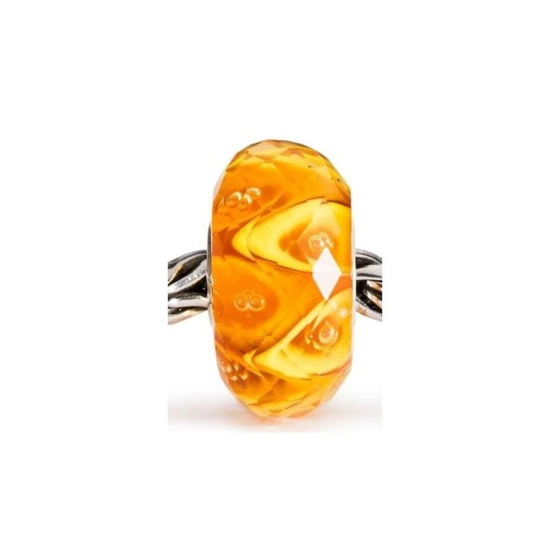 Perle Trollbeads Enchantement lumineux à facettes en verre ambré enfilée sur une chaîne de bracelet
