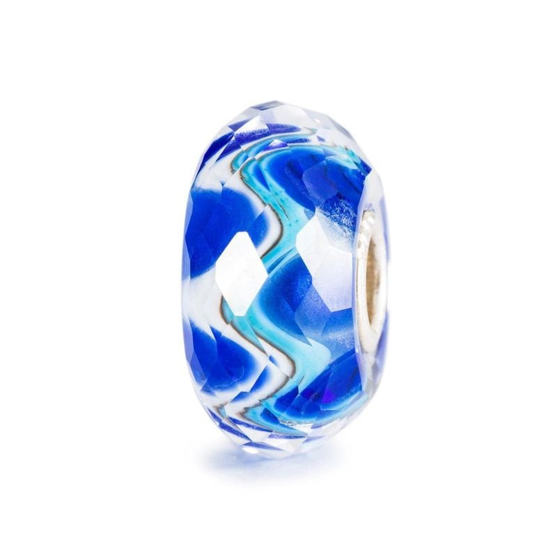 Perle en verre Trollbeads Harmonie à Facettes isolée sur fond blanc, volutes facettées bleu et blanc