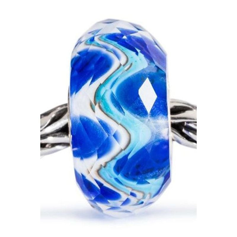 Gros plan de la perle Trollbeads Harmonie à Facettes sur bracelet argent, verre facetté bleu blanc t