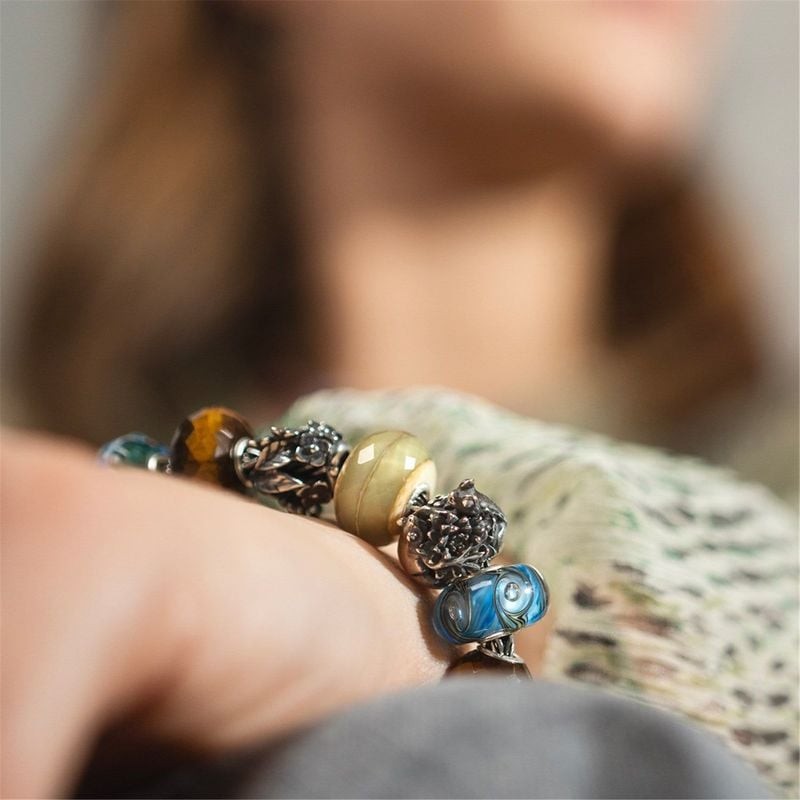 Perle Trollbeads Carpe Diem Ondes Verre Bleu portée sur un bracelet, évoquant les vagues et la fluid