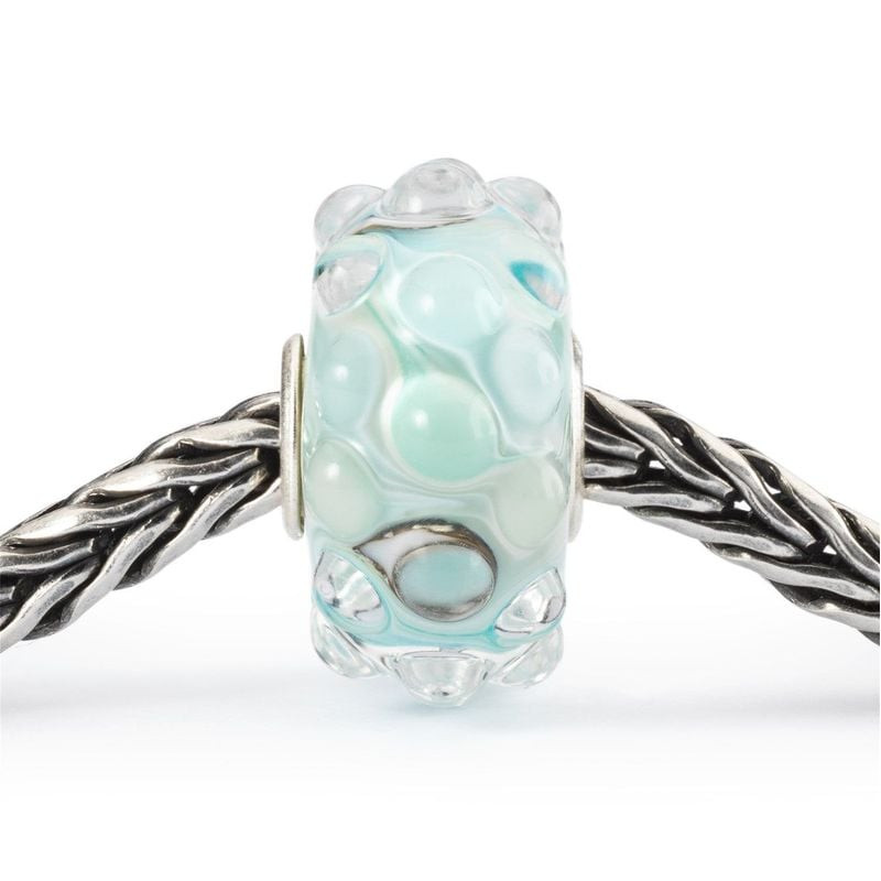 Perle Trollbeads Vue sur Mer enfilée sur un bracelet tressé en argent 925, au design bleu-vert océan