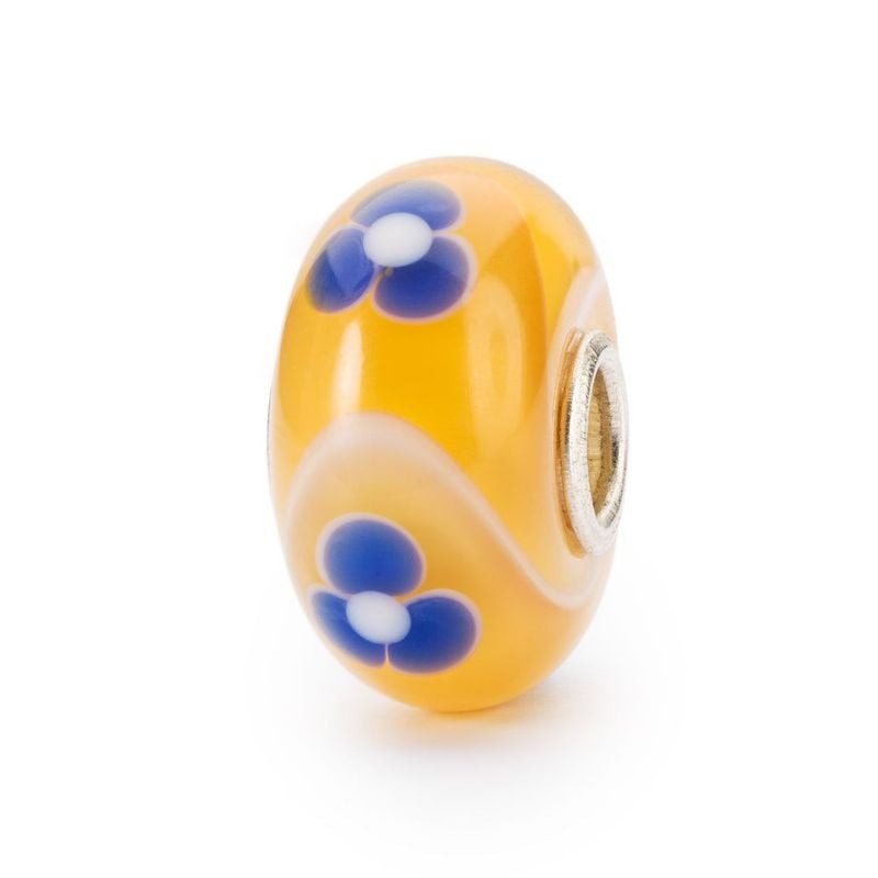 Vue de côté de la perle Trollbeads Paradis du Tatou en verre de Murano avec fleurs bleues et cœur en
