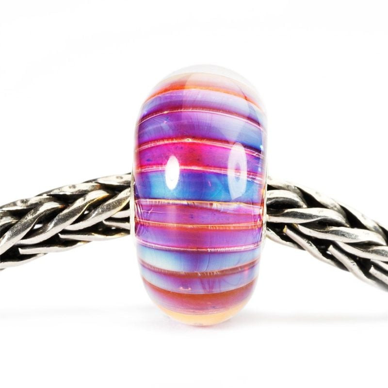 Perle en verre Trollbeads Rayure d'Aurore, rayures irisées roses, violettes et bleues, enfilée sur u