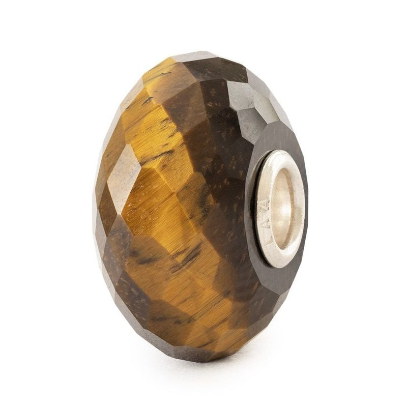 Vue inclinée de la perle Trollbeads Œil de Tigre Jaune montrant sa surface facettée et son noyau en 