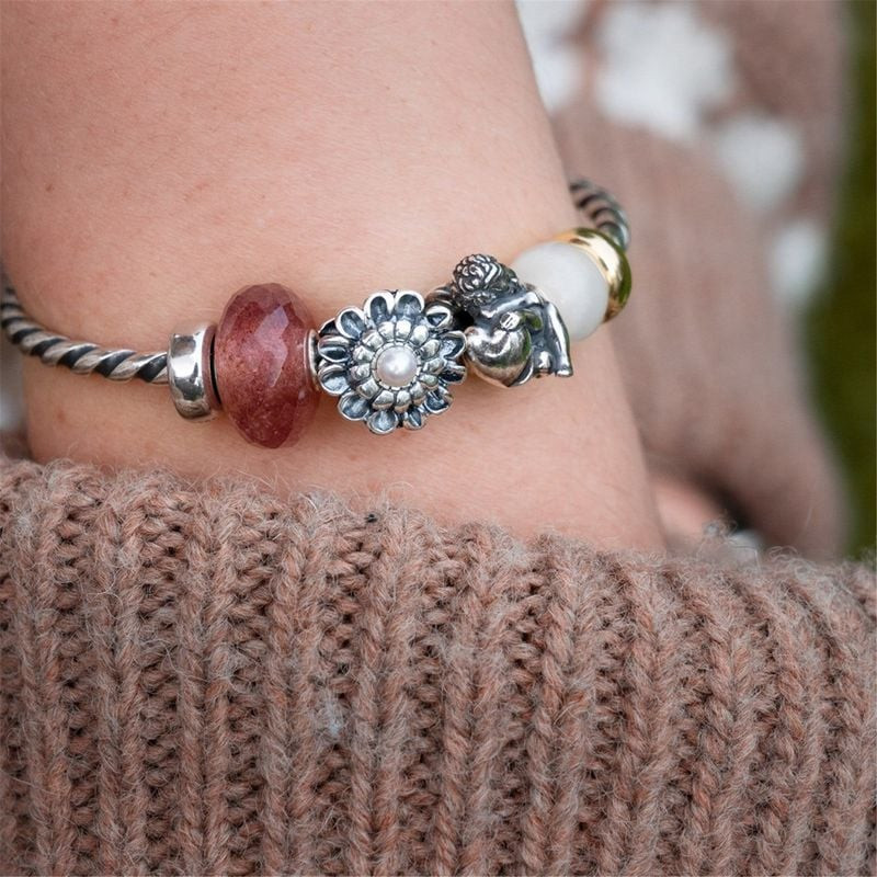 Charm Trollbeads Fraise Pierre Rose porté sur un bracelet, élégant et naturel.
