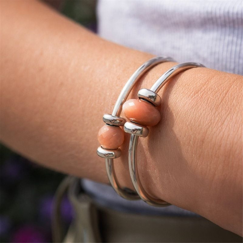 Perle Charm Trollbeads Feldspar Moonstone Pierre de Lune portée au poignet dans un style de vie élég
