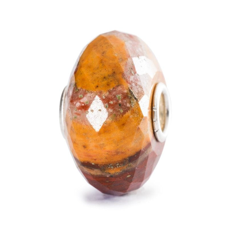 Perle Trollbeads calcédoine marron et jaune facettée, vue de profil sur fond blanc avec bandes natur