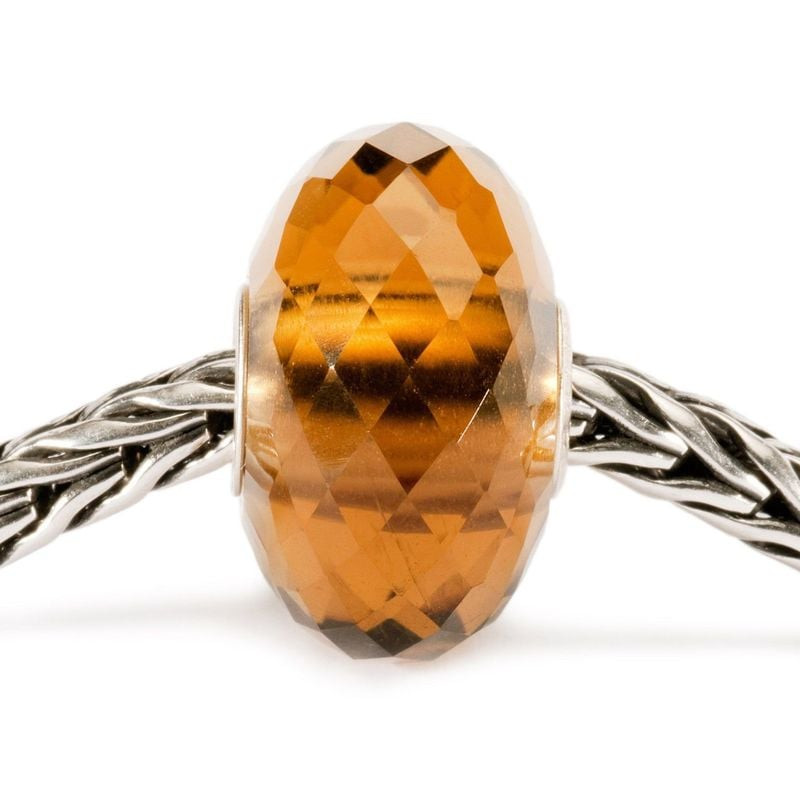 Perle de charme Trollbeads Quartz Or enfilée sur un bracelet en argent tressé, vue rapprochée