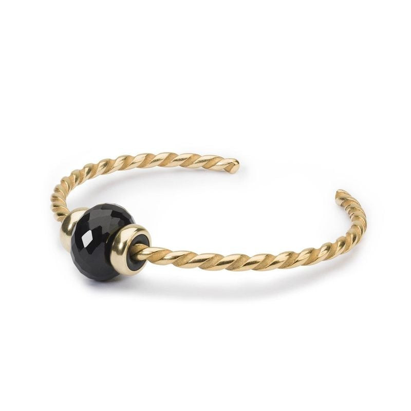 Perle Trollbeads Onyx noir facettée sur un bracelet jonc torsadé doré