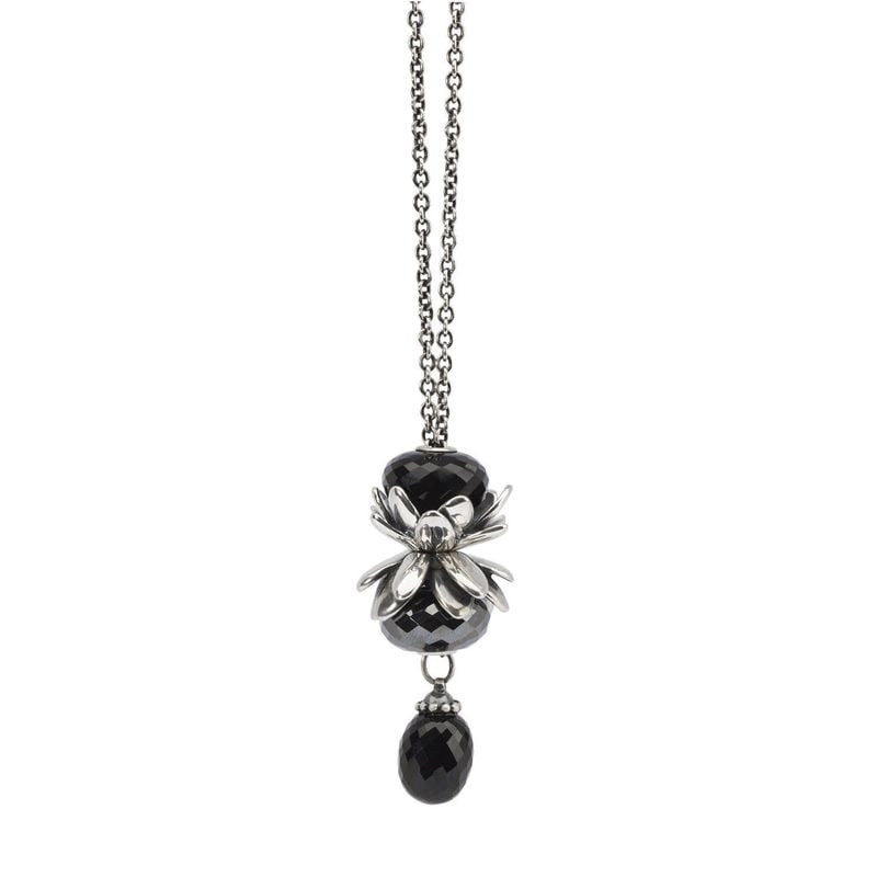 Perle Trollbeads Onyx noir associée à une breloque fleur en argent sur un collier pendentif