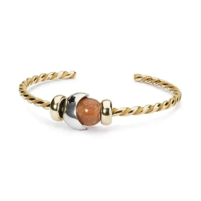 Perle Trollbeads Ronde en Pierre de Soleil sur fond neutre, mettant en valeur ses reflets dorés et s