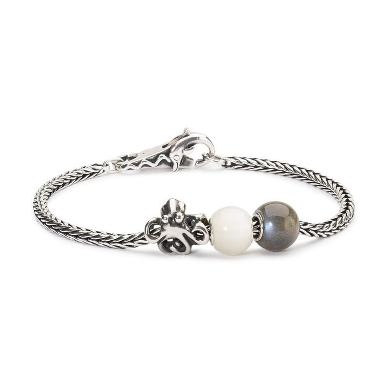 Perle Trollbeads Ronde Labradorite à Enfiler en gros plan, reflets irisés bleu et vert, ambiance dou