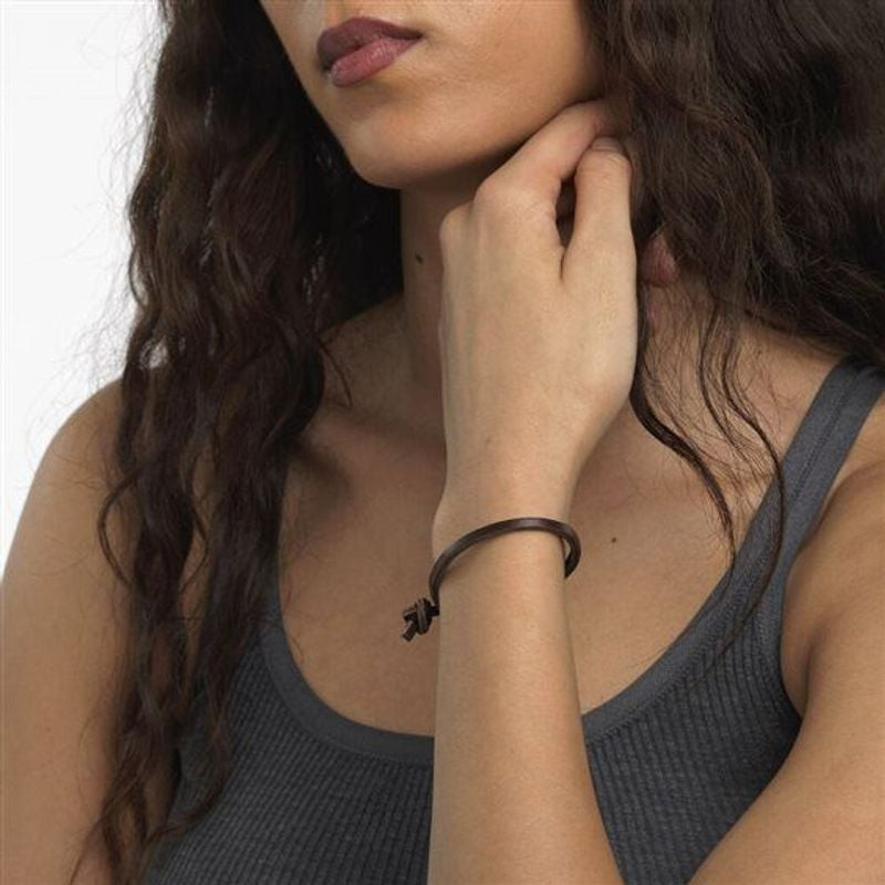 Modèle portant le bracelet en cuir marron Trollbeads à son poignet, avec un débardeur gris et des on
