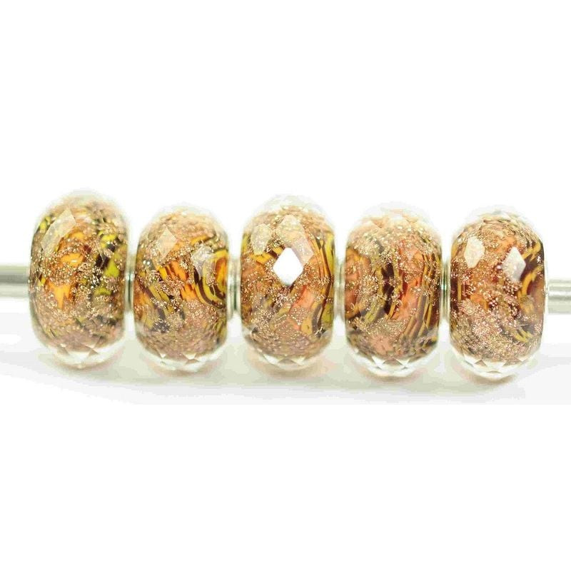 Cinq perles Trollbeads Golden Earth en verre aux facettes et motifs brun doré scintillants sur une t