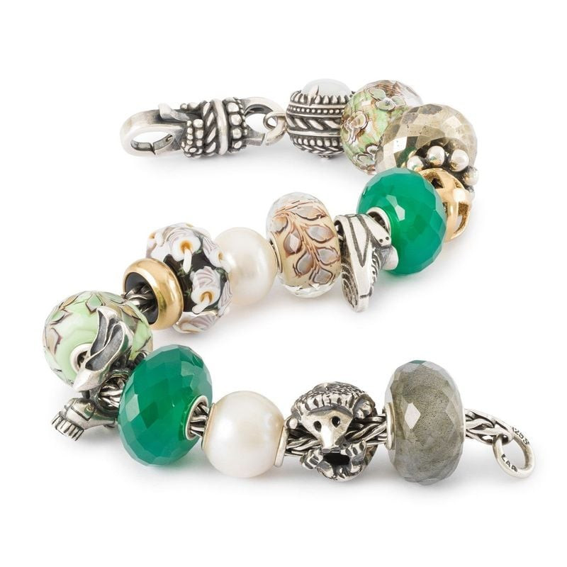 Un bracelet Trollbeads orné de la perle FEUILLES OSCILLANTES, mélangée à d'autres perles Trollbeads 