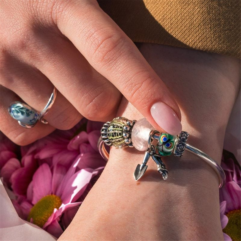 Gros plan sur un poignet portant un bracelet Trollbeads en argent avec la perle Panier de l'Espoir e