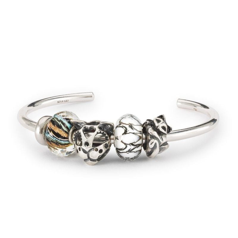 Perle en verre Trollbeads Bubble Drift portée sur un jonc en argent avec d'autres charms et perles e