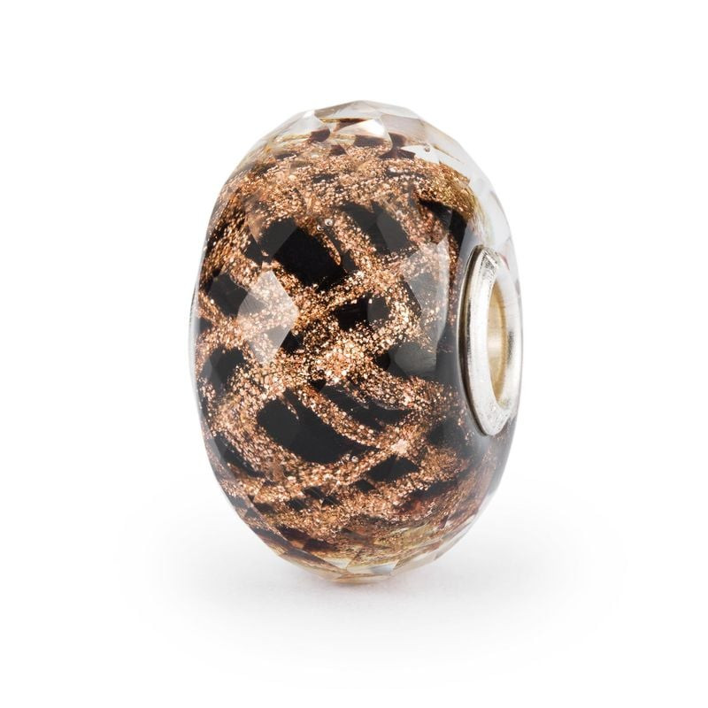 Perle Trollbeads Happy 2023 en édition limitée, verre noir facetté et paillettes dorées sur fond bla
