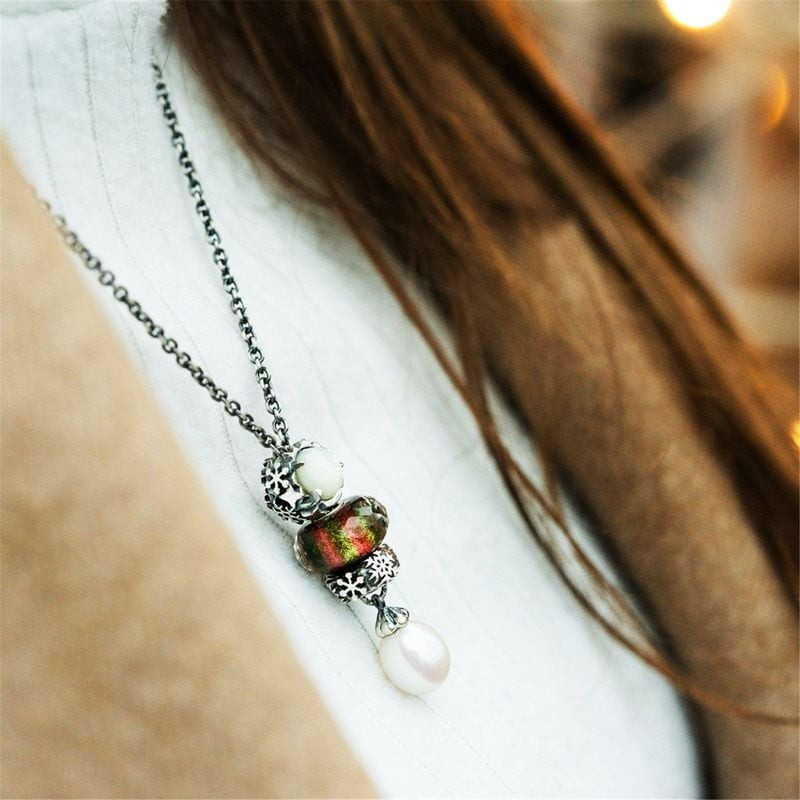 Modèle portant un collier en argent avec la perle de Noël en verre vert et rouge Trollbeads