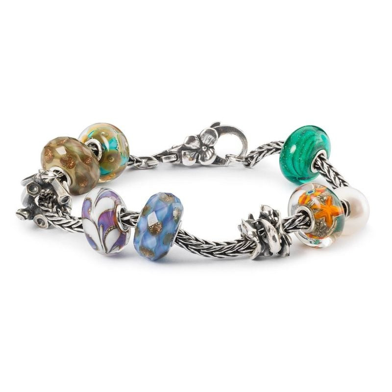 Perle Trollbeads Rivière d'Or Verre Bleu en verre facetté bleu indigo et reflets dorés dans une ambi