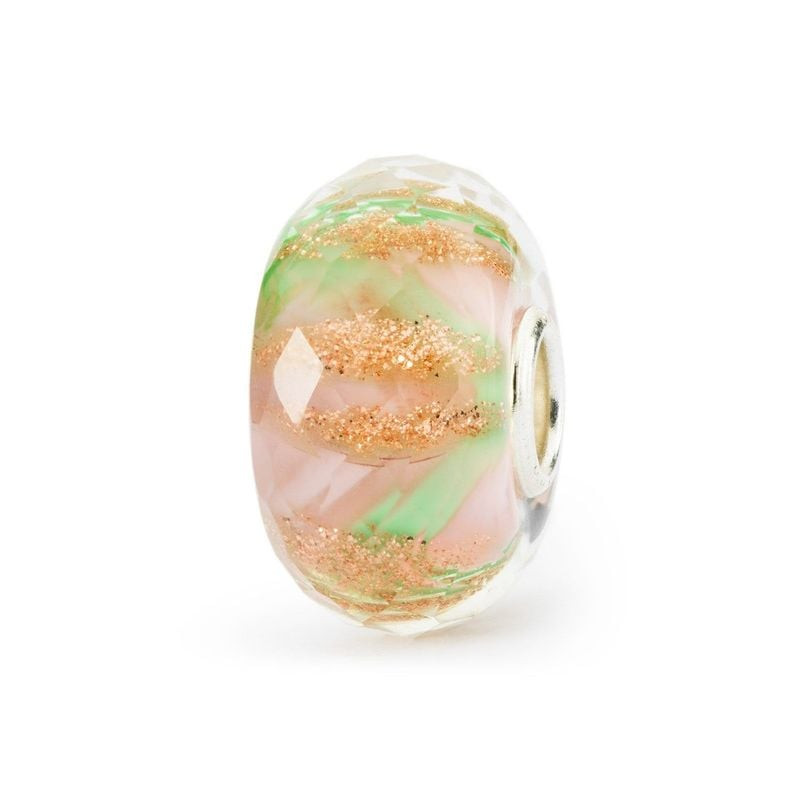 Gros plan sur la perle en verre TROLLBEADS LIT DE FLEURS, dévoilant son motif floral pastel et ses p