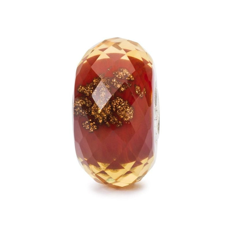Charm Trollbeads en verre de Murano rouge à facettes avec paillettes dorées sur fond blanc