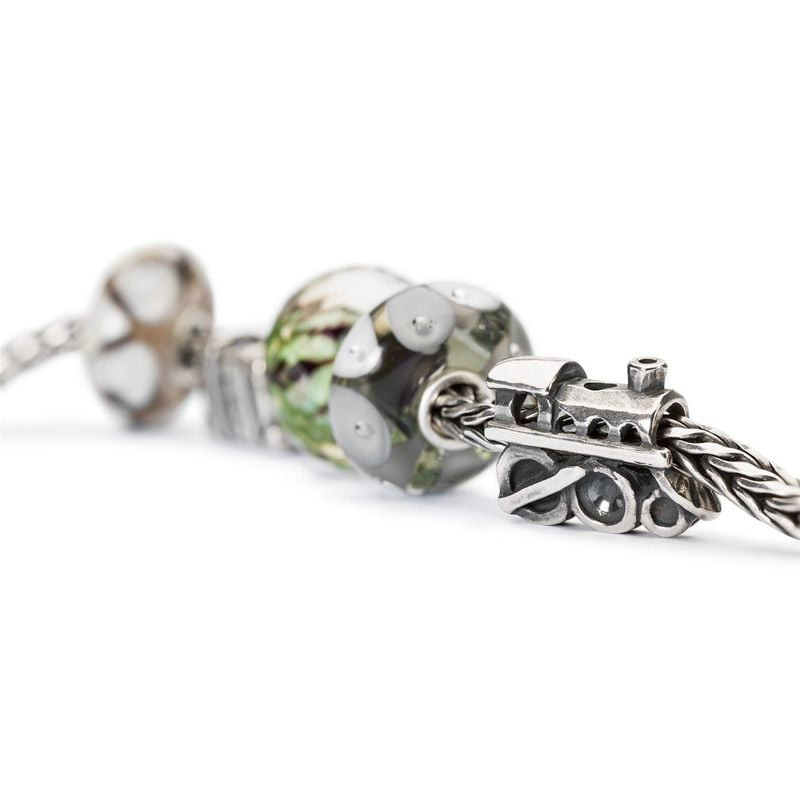 Perle de verre Trollbeads Jungle avec un charm de train en argent sur une chaîne tressée, faible pro