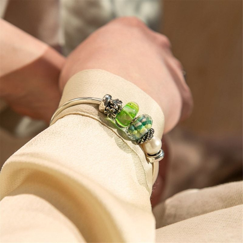 Perle Trollbeads Paisible Horizon Verre Vert montée sur un bracelet, dans une ambiance naturelle apa