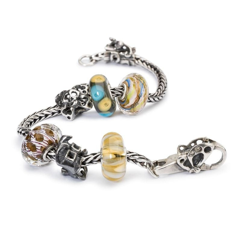 Bracelet argent Trollbeads avec perle de verre Île déserte et autres charms sur fond blanc