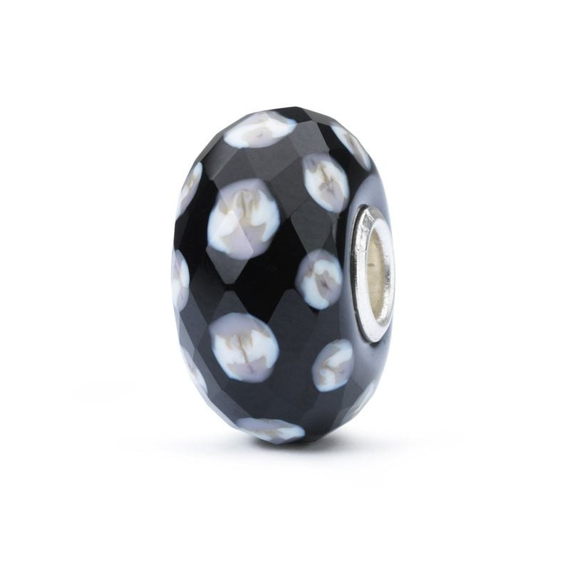 Perle de verre Trollbeads Gouttes de pluie, sur fond blanc, surface noire facettée, taches florales 