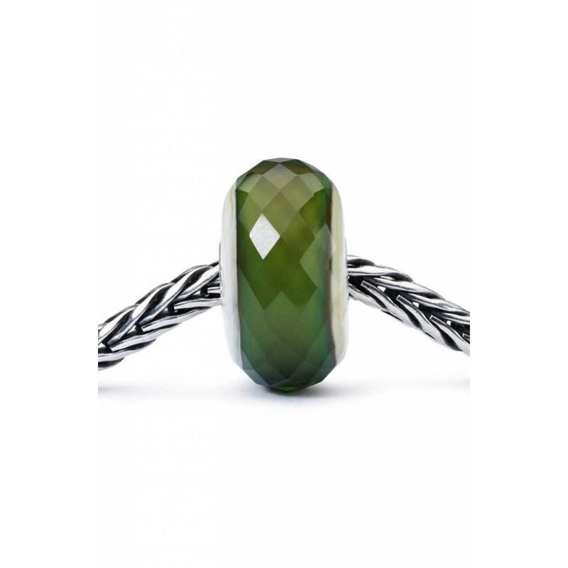 Perle Trollbeads Vert furtif en verre vert facetté enfilée sur un bracelet Trollbeads en argent ster