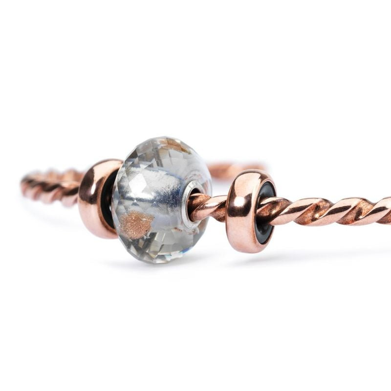 Détail de la Perle Trollbeads Éclat du Jour Facettée Verre Gris avec reflets cuivrés.