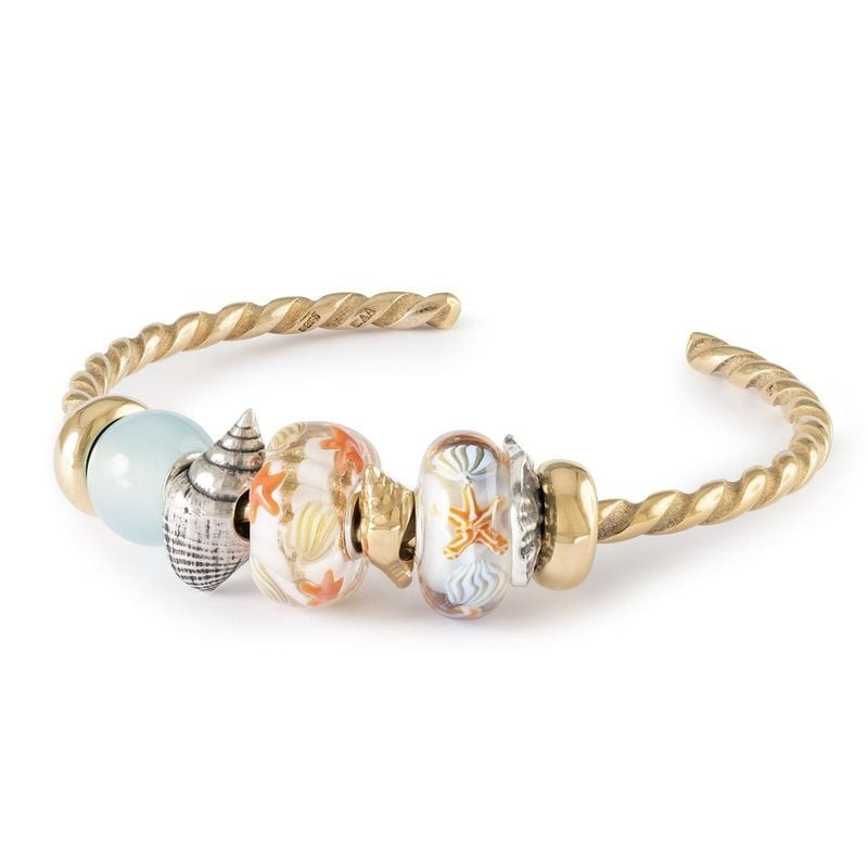 Bracelet jonc Trollbeads doré avec la perle Guidé par les Vagues, une breloque escargot de mer et un