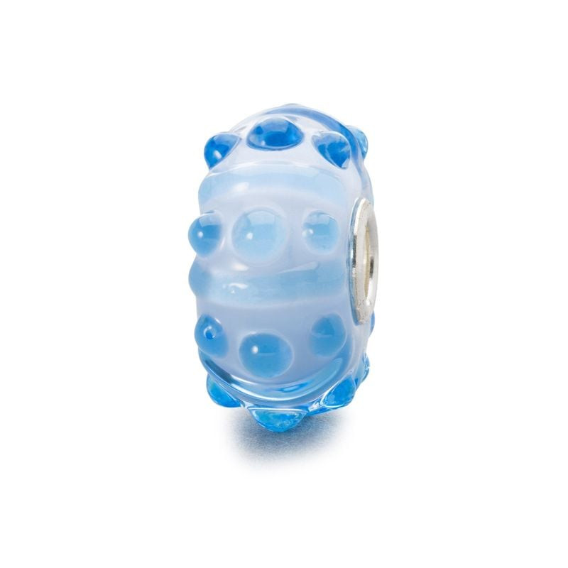 Perle Trollbeads Brise Bleue en verre avec reliefs bleus et cœur argent sur fond blanc