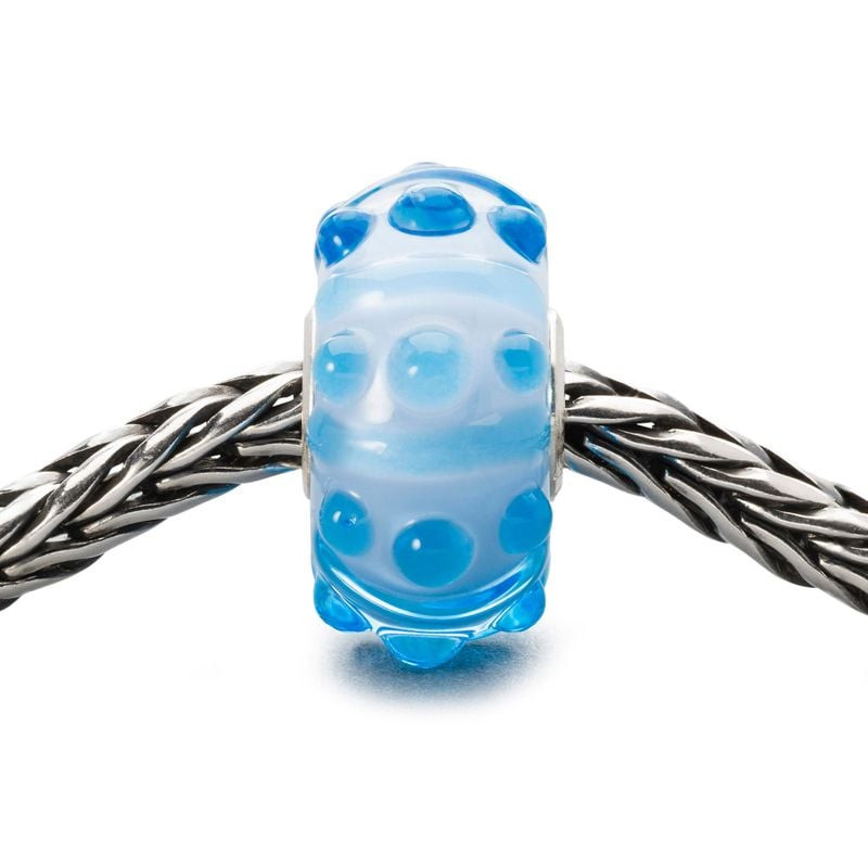 Perle de verre Trollbeads Brise Bleue enfilée sur un bracelet en argent tressé, vue de côté.